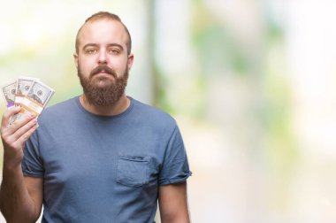 Acımak yüz ciddi düşünüyorum üstünde kendine güvenen bir ifade ile izole arka plan üzerinde para tutan genç hipster adam