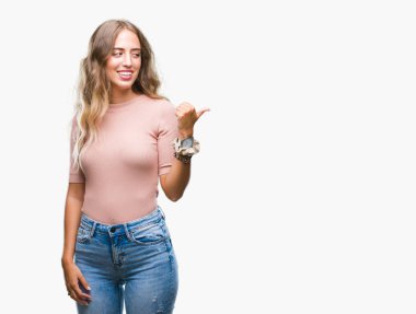 Seyir ve başparmak yanında yukarıyı mutlu yüz ile gülümseyen izole arka plan üzerinde sarışın güzel genç kadın.