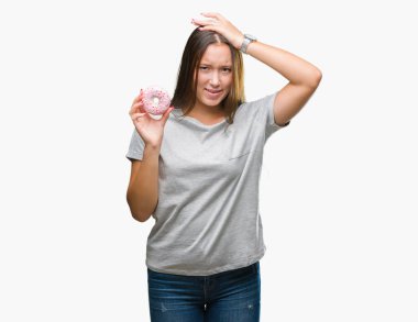 Baş, el ile vurguladı izole arka plan üzerinde tatlı çörek yeme genç kafkas kadın şok utanç ve sürpriz suratla, öfkeli ve sinirli. Korku ve hata için üzgün.