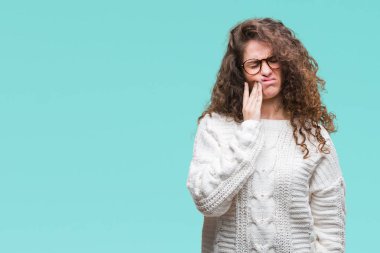 Güzel esmer kıvırcık saçlı Genç kız acı ifadesi ile el ile ağız diş ağrısı veya dişlerde dişlerle ilgili hastalık nedeniyle dokunmadan izole arka plan üzerinde kış kazak giyiyor. Diş hekimi kavramı.