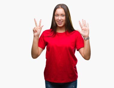 Genç güzel beyaz kadın gösterilen ve parmakları ile işaret izole arka plan yüzünden kendinden emin ve mutlu gülümseyerek süre sekiz numara.