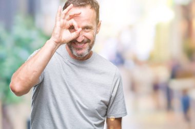 Orta yaş üst düzey ağarmış adam gülümsüyor, parmakları ile mutlu yüz üzerinden seyir göz el ile ok jest yapıyor izole arka plan üzerinde.