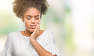 Diş ağrısı veya dişlerde dişlerle ilgili hastalık nedeniyle ağız acı ifadesi ile el ile dokunmak izole arka plan üzerinde genç afro Amerikalı kadın. Diş hekimi kavramı.