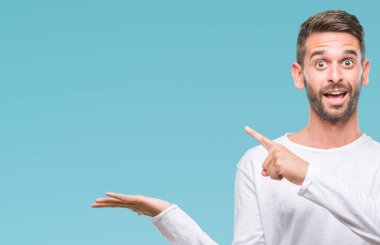 Yakışıklı delikanlı üzerinden hayran ve el ile sunulması ve parmak ile işaret ederken kameraya gülümseyen izole arka plan.