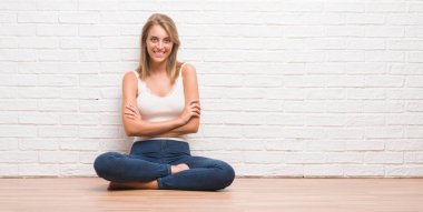 Ev mutlu yüz ile gülümseyen, yerde oturan güzel genç kadın silah kameraya bakarak geçti. Olumlu bir kişi.