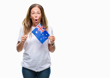 Avustralya bayrağı izole arka plan üzerinde bir sürpriz yüz, korkuyor ve heyecanlı korku ifadesi ile şok korkmuş tutan orta yaş İspanyol kadın