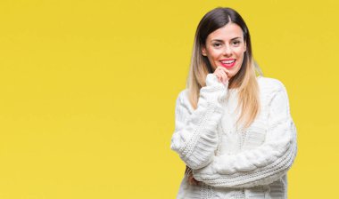 Genç güzel kadın rahat beyaz kazak emin çapraz kollar ve çeneme kaldırdı el ile gülümseme ile kameraya bakarak izole arka plan üzerinde. Pozitif düşünce.