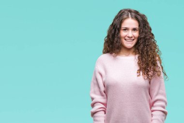 Güzel esmer kıvırcık saçlı Genç kız yüzünde mutlu ve güzel bir gülümseme ile izole arka plan üzerinde pembe kış kazak giyiyor. Şanslı kişi.