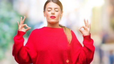 Kış kazak izole arka plan üzerinde dinlenmek giydiği ve gözleri ile gülümseyen genç güzel iş kadını parmak ile meditasyon jest yapıyor kapalı. Yoga kavramı.