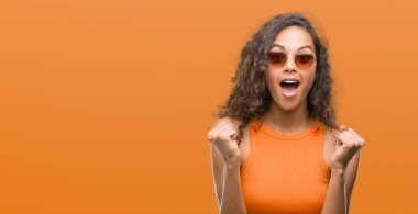 Duygu tezahürat gurur çığlık ve zafer ve başarı çok heyecanlı, kutluyor yaz kıyafeti giyen genç İspanyol kadın