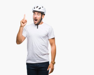 Genç yakışıklı adam başarılı fikirle izole arka plan işaret parmağı üzerinde bisikletçi Güvenlik kask giyiyor. Çıktıktan ve mutlu. Bir numara.