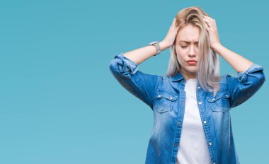 Sarışın, izole edilmiş, baş ağrısı çeken, çaresiz ve stresli genç bir kadın. Ağrı ve migren yüzünden. Ellerini başının üstüne koy..