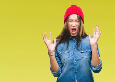 Yün kap üzerinde giyen genç beyaz güzel kadın deli ve çılgın çığlık kaldırdı ve kapalı gözleri heyecanlı silah ile başarı için arka plan kutlama izole. Kazanan kavramı