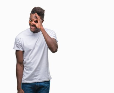 Genç Afro-Amerikan adam gülümsüyor, parmakları ile mutlu yüz üzerinden seyir göz el ile ok jest yapıyor izole arka plan üzerinde.