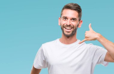 Yakışıklı delikanlı yapıyor gülümseyen izole arka plan üzerinde telefon hareketi ile el ve parmak telefonda konuşuyor gibi. Kavramları iletişim.