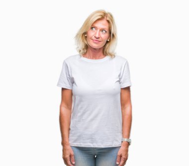 Orta yaş sarışın kadın görünümlü yan ve dik dik bakma uzağa düşünce gülümseyen izole arka plan üzerinde.