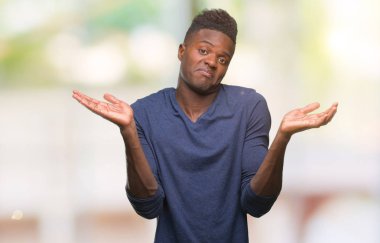Afrikalı-Amerikalı genç izole arka plan clueless ve şaşkın bir ifadeyle kollar ve eller ortaya çıkar üzerinden. Şüphe kavramı.