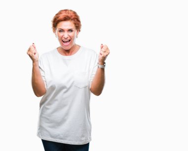 Atrractive üst düzey beyaz Kızıl saçlı kadın kutluyor izole arka plan üzerinde şaşırttı ve başarı için kaldırdı kollarını açarak hayret ve gözleri açık. Kazanan kavramı.