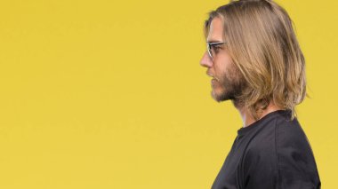 İzole arka tarafına, seyir üzerinde güneş gözlüğü takmış uzun saçlı Genç yakışıklı adam sakin ol kendine güvenen gülümseme ile doğal yüz pozuyla profili.
