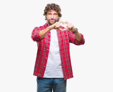 Yakışıklı İspanyol modeli adam aşık kalp simgesi ve elleriyle şekil gösteren gülümseyen izole arka plan üzerinde. Romantik kavramı.