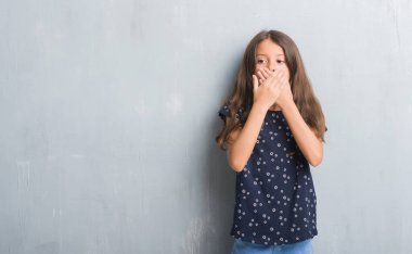 Grunge gri duvar eller için hata ile ağız kapsayan şok genç İspanyol çocuk. Gizli kavramı.