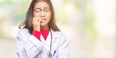 Genç Arap doktor kadın yüzünden stresli ve gergin elle çivi ısırma ağzına bakarak izole arka plan. Anksiyete sorunu.