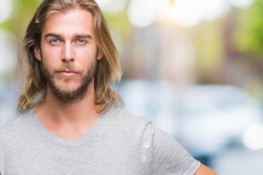 Futbol topu kendine güvenen bir ifade ile acımak yüz ciddi düşünüyorum tutarak izole arka plan üzerinde uzun saçlı yakışıklı delikanlı