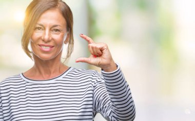 Orta yaş İspanyol kadın kıdemli izole arka plan gülümseyen ve süre seyir ve kamera boyutu işaret parmaklarıyla yapıyor el ile kendinden emin eller üzerinde. Ölçü kavramı.