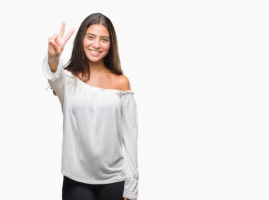 Genç güzel Arap kadın mutlu yüz zafer işareti yaparken kameraya göz kırpıyor ile gülümseyen izole arka plan yüzünden. İki numaralı.