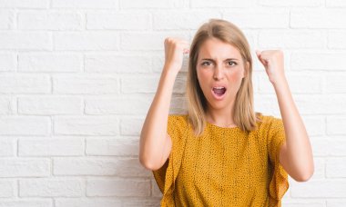 Güzel genç kadın yüzünden beyaz tuğla duvar rahatsız ve sinirli öfkeyle, çılgın ve yükseltilmiş eliyle diye bağıran öfke kavramı bağırarak