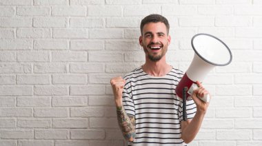 Duygu tezahürat gurur çığlık ve zafer ve başarı çok heyecanlı, kutluyor megafon tutan genç yetişkin adam