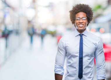 Afro Amerikan iş adamı yüzünde mutlu ve güzel bir gülümseme ile izole arka plan üzerinde gözlük takıyorum. Şanslı kişi.
