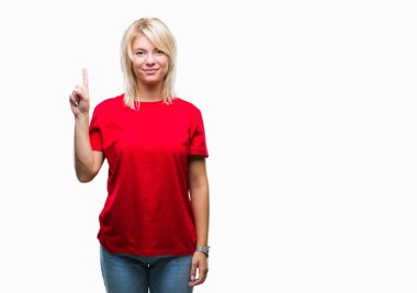 Ve kendinden emin ve mutlu gülümseyerek süre parmak numaralı yukarıyı gösteren izole arka plan üzerinde kırmızı t-shirt giyen genç güzel sarışın kadın.