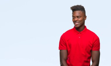 Afrikalı-Amerikalı genç uzak tarafına yüzünde, doğal ifade gülümseme ile seyir izole arka plan üzerinde. Kendine güvenen gülüyor.