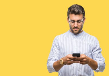 Genç yakışıklı adam manifatura smartphone akıllı yüzünde ciddi düşünme emin bir ifade ile izole arka plan üzerinde kullanma