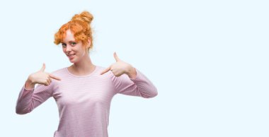 Yüzünde gülümseme ile kendinden emin görünüyorsun, kendini gururlu ve mutlu parmakları ile işaret genç Kızıl saçlı kadın.