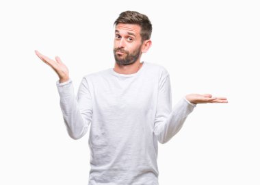 İzole arka plan clueless ve şaşkın bir ifadeyle kollar ve eller kaldırdı genç yakışıklı adam. Şüphe kavramı.