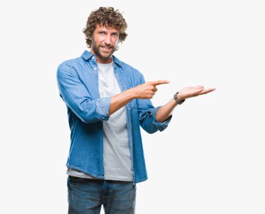 Yakışıklı İspanyol modeli adam üzerinden hayran ve el ile sunulması ve parmak ile işaret ederken kameraya gülümseyen izole arka plan.