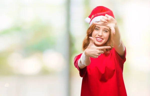 笑顔の幸せそうな顔で指と手作りフレーム クリスマス帽子をかぶっている孤立した背景に若くてきれいな女性 創造性と写真のコンセプト — ストック写真
