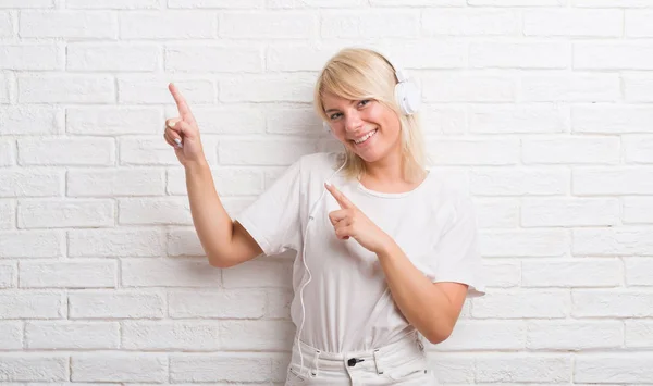 Mulher Caucasiana Adulta Sobre Parede Tijolo Branco Usando Fones Ouvido — Fotografia de Stock