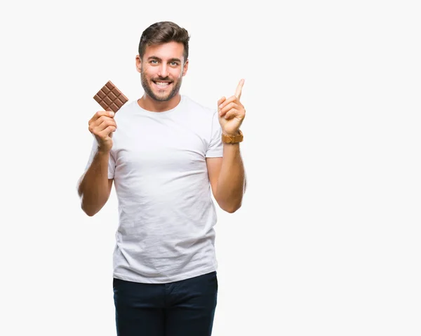 Young Handsome Man Eating Chocolate Bar Isolated Background Very Happy — Stock Photo, Image