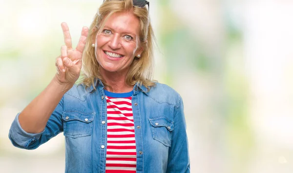 Middle age blonde woman over isolated background showing and pointing up with fingers number two while smiling confident and happy.