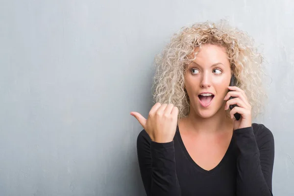 Giovane Donna Bionda Sfondo Grigio Grunge Parlando Telefono Indicando Mostrando — Foto Stock