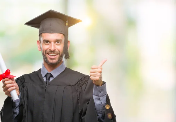 若いハンサムな卒業男笑顔の サイン 優秀な兆候を親指をやって幸せな孤立の背景の上の学位を保持 — ストック写真