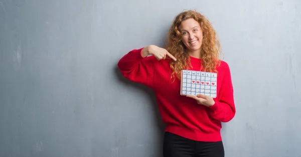 Joven Pelirroja Mujer Sobre Gris Grunge Pared Celebración Período Calendario — Foto de Stock