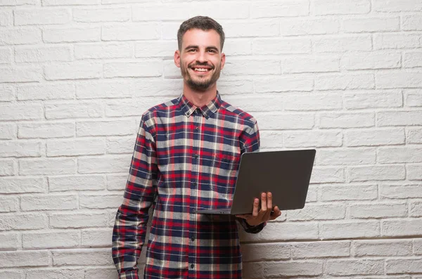 Молодий Дорослий Чоловік Над Цегляною Стіною Використовує Ноутбук Щасливим Обличчям — стокове фото