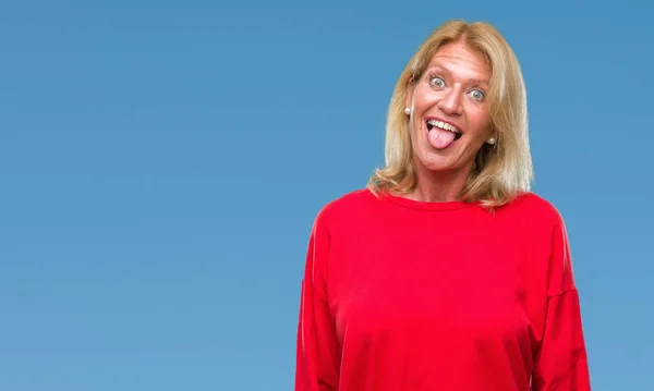 Middle age blonde woman over isolated background sticking tongue out happy with funny expression. Emotion concept.