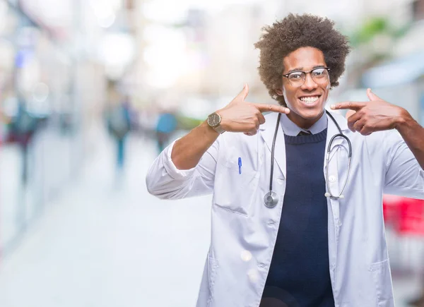 美国黑人医生在孤立的背景下微笑着自信地显示和指着手指的牙齿和嘴巴 健康理念 — 图库照片