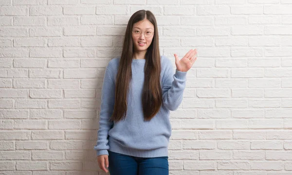 Chinise Mladá Žena Nad Bílou Cihlová Zeď Znázorňující Ukázal Prsty — Stock fotografie