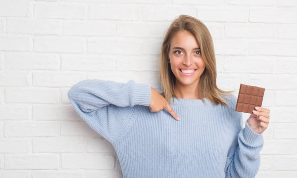 Schöne Junge Frau Über Weiße Backsteinmauer Essen Schokoriegel Mit Überraschung — Stockfoto